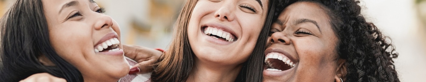 Three woman laughing outdoors after receiving dental services in Albuquerque