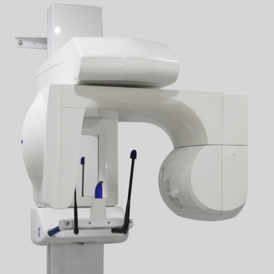 Cone beam C T scanner standing against white wall