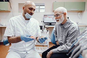 Dentist showing patient model of denture
