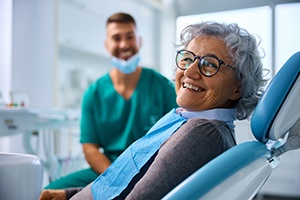 Patient with black glasses smiling in treatment chair