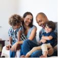 Smiling family of four sitting on couch