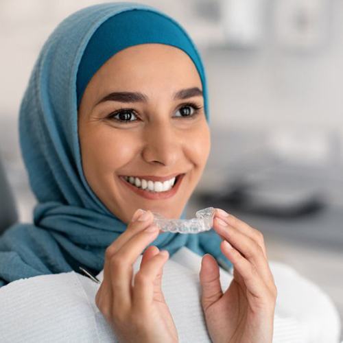 Patient in Albuquerque holding their Invisalign aligner