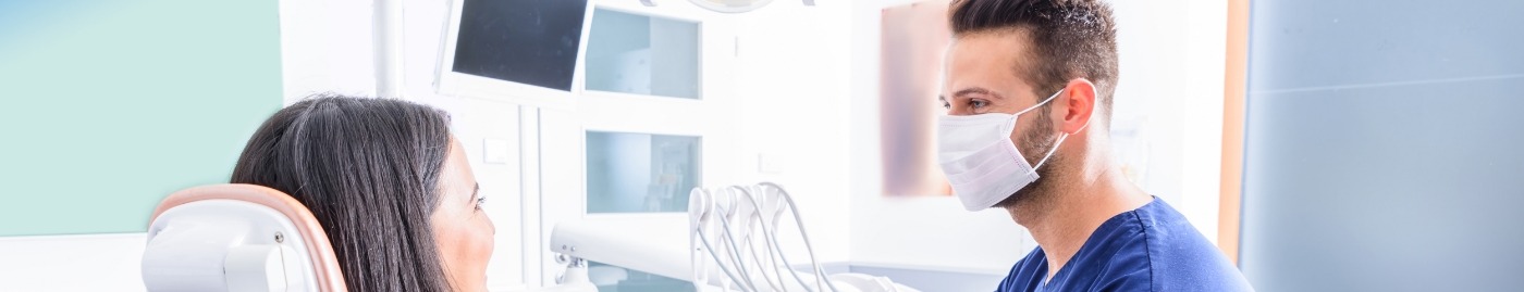 Woman in dental chair smiling at her dentist