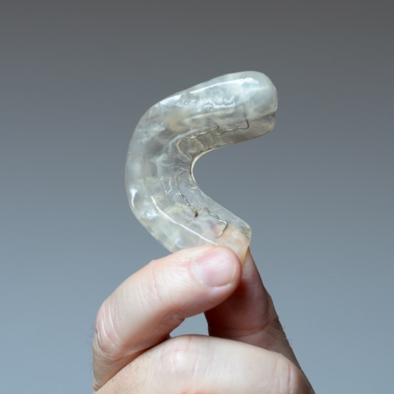 Hand holding a white nightguard