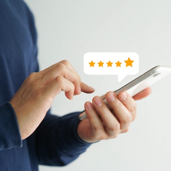 Person using their phone to leave a five star dentist review